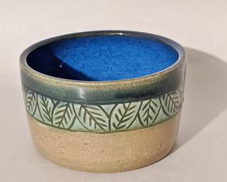 Adorn your home with this stunning little carved planter with lovely green and blue glazes.