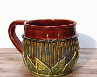 A hefty ceramic mug with a gorgeous color palette around the outside and red on the inside.