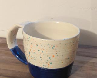 Bright blue and speckled ceramic mug.