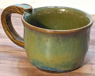 A hefty ceramic mug with a gorgeous sea green and blue drip around the outside.
