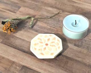 A tiny tealight candle holder/coaster to protect your table.