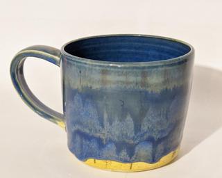 A hefty ceramic mug with a gorgeous wavy blue drip around the outside with a bright blue on the inside.