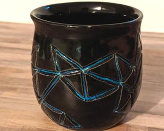 Decorate your home with this hand carved ceramic planter with a unique geometric design.