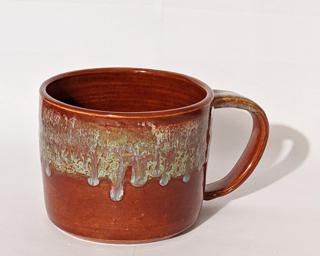 A hefty ceramic mug with a gorgeous red and blue drip around the outside with a red and yellow on the inside.
