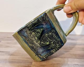 A lovely ceramic mug with carved bamboo around the outside.