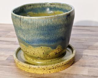 Adorn your home with this one of a kind speckled ceramic planter, complete with a drain hole on the side and a small attached dish to catch any water overflow.
