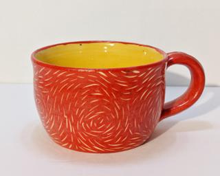 A brightly colored ceramic mug, perfect for a morning cup of coffee.