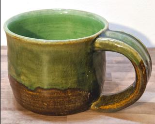 A hefty ceramic mug with a gorgeous olive green drip around the outside.