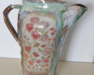 This large hand built decorative pitcher is sure to catch anyone's eye.