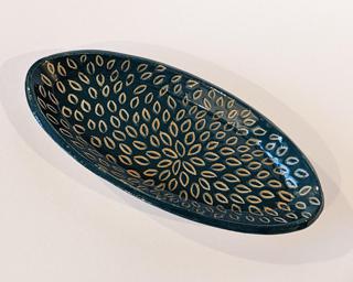A small oval shaped dish with little carved petals.