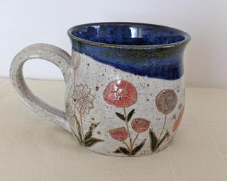A carefully painted and carved ceramic mug, perfect for your morning cup of tea or coffee.