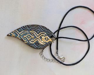 A lovely textured leaf pendant finished with a shiny gold lustre finish.