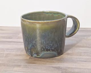 A lovely ceramic mug with unique blend of drippy glazes around the outside.