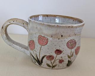 A carefully painted and carved ceramic mug, perfect for your morning cup of tea or coffee.