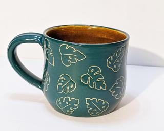A carefully carved ceramic mug, perfect for a morning cup of coffee.