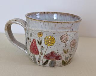 A carefully painted and carved ceramic mug, perfect for your morning cup of tea or coffee.