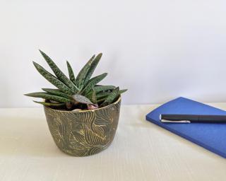 An intricately carved planter for your table.