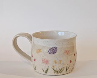 Mug with hand-painted flowers and a white glaze on the inside and around the rim.