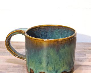 A hefty ceramic mug with a gorgeous sea green and blue drip around the outside.