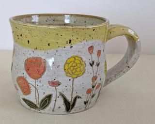 A carefully painted and carved ceramic mug, perfect for your morning cup of tea or coffee.