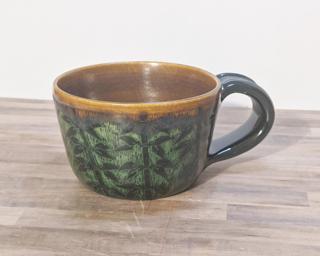 A carefully carved ceramic mug, perfect for a morning latte.