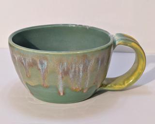 A lovely ceramic mug with unique blend of drippy glazes around the outside.