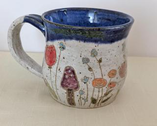 A carefully painted and carved ceramic mug, perfect for your morning cup of tea or coffee.