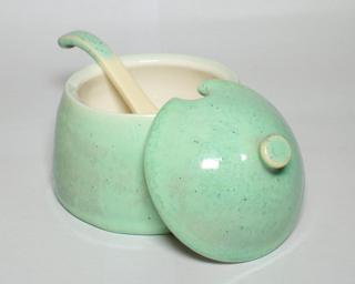 A whimsical little ceramic pot that can hold sugar, salt, or spices.