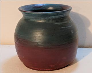 Adorn your home with this hefty and one of a kind dark burgundy and peacock colored planter.