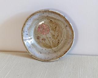 A little handmade square dish decorated with a variety of colorful flowers which have been carefully carved for added detail.