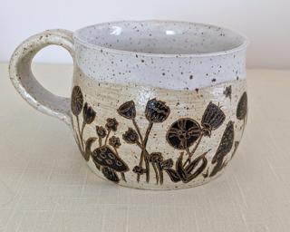 A carefully painted and carved ceramic mug, perfect for your morning cup of tea or coffee.